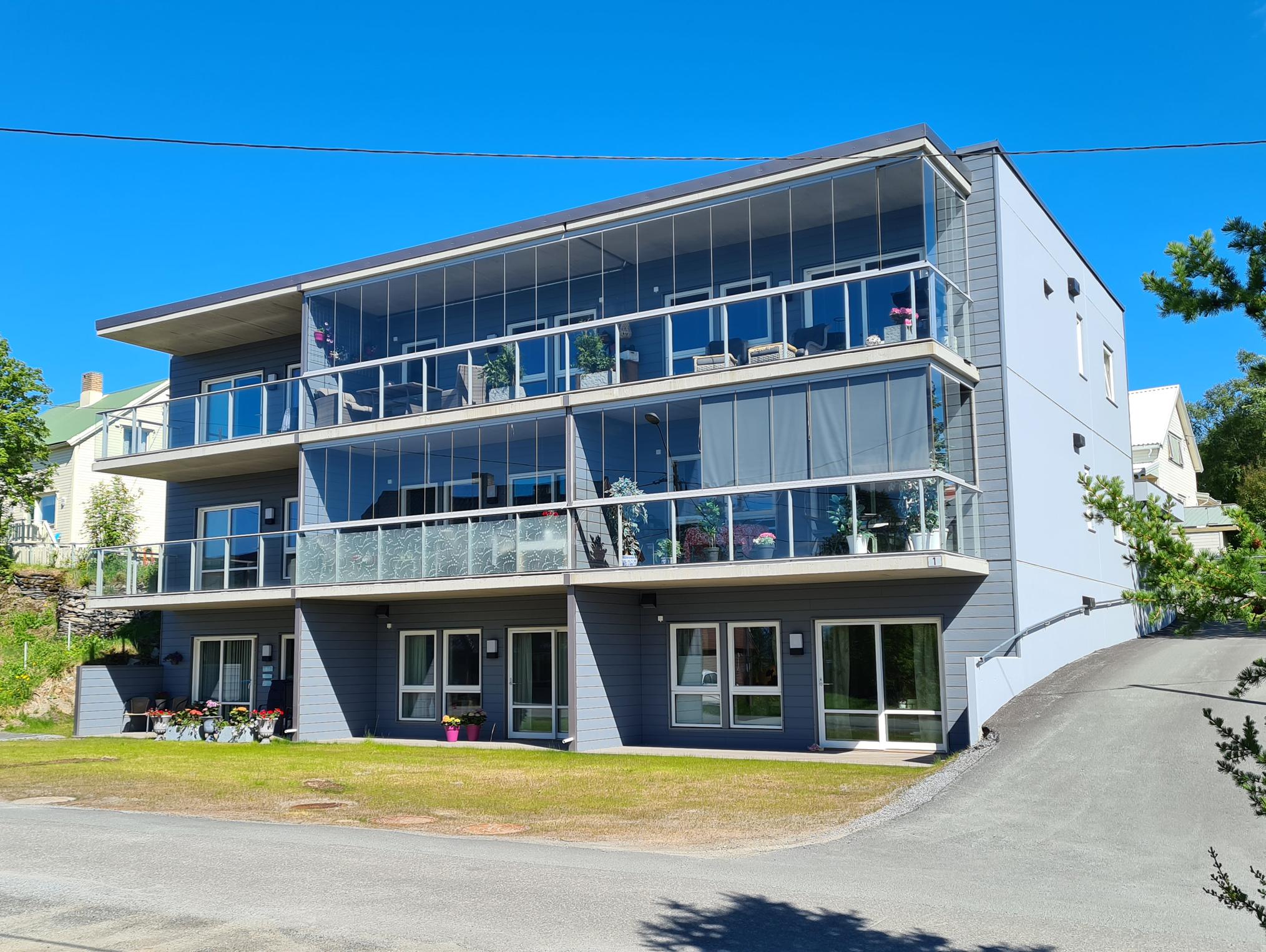 Nytt leilighetsbygg i tre etasjer med glassrekkverk på balkongene, Nyvenget